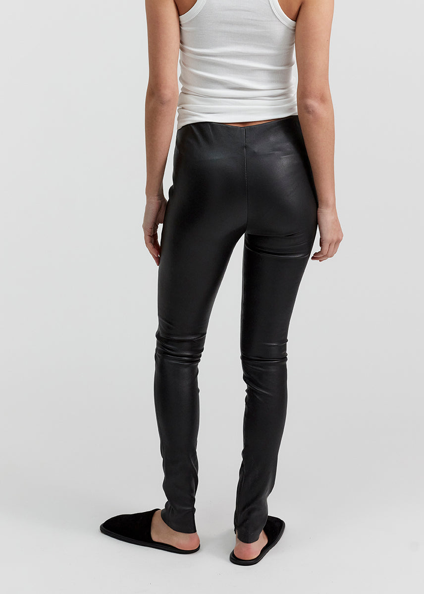 13541 LUKE UTZON aw24 black elastic lamb leather leggings styled with white tanktop and black slippers closeup of legs from the back