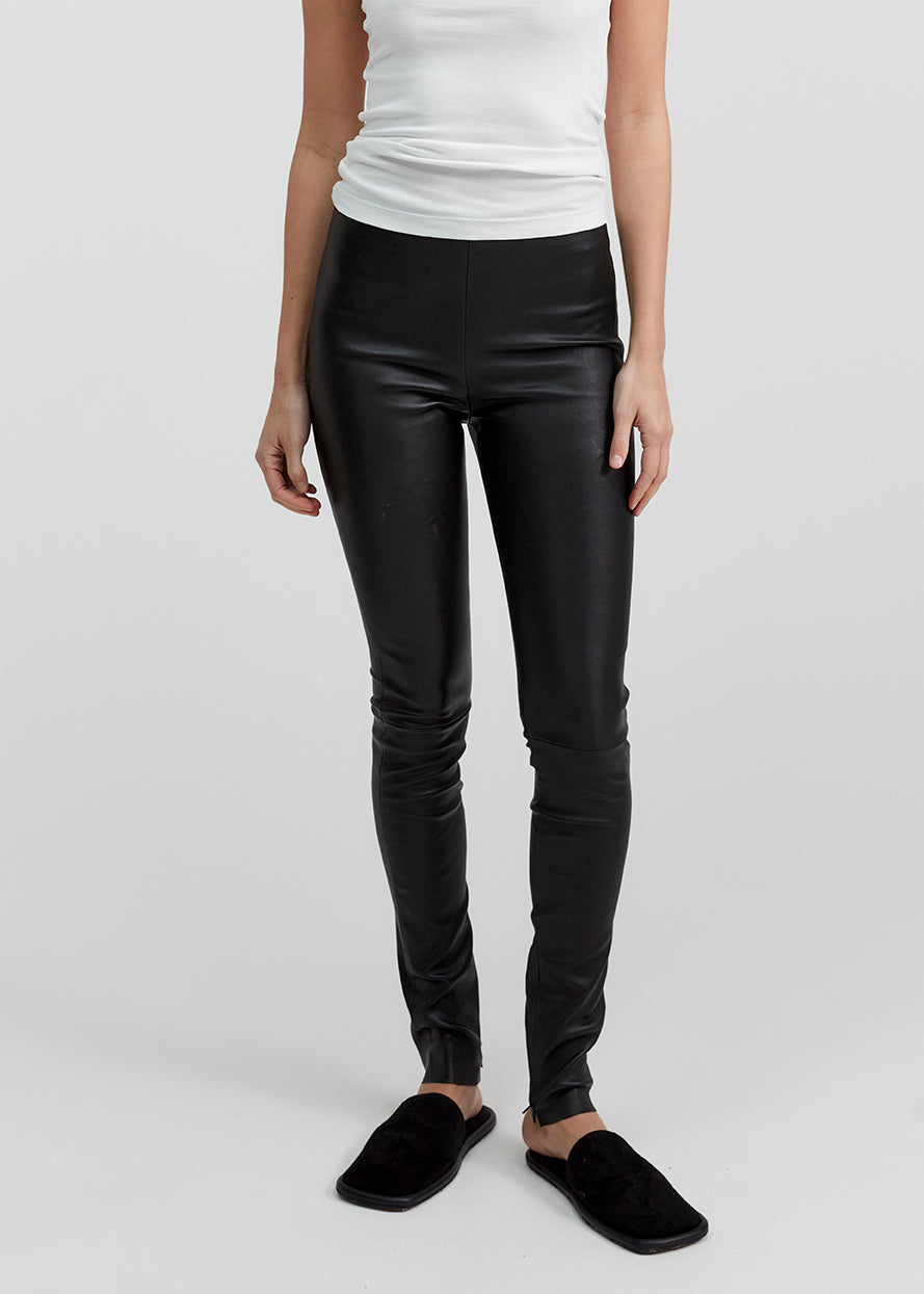 13541 LUKE UTZON aw24 black elastic lamb leather leggings styled with white tanktop and black slippers closeup of legs and tummy front