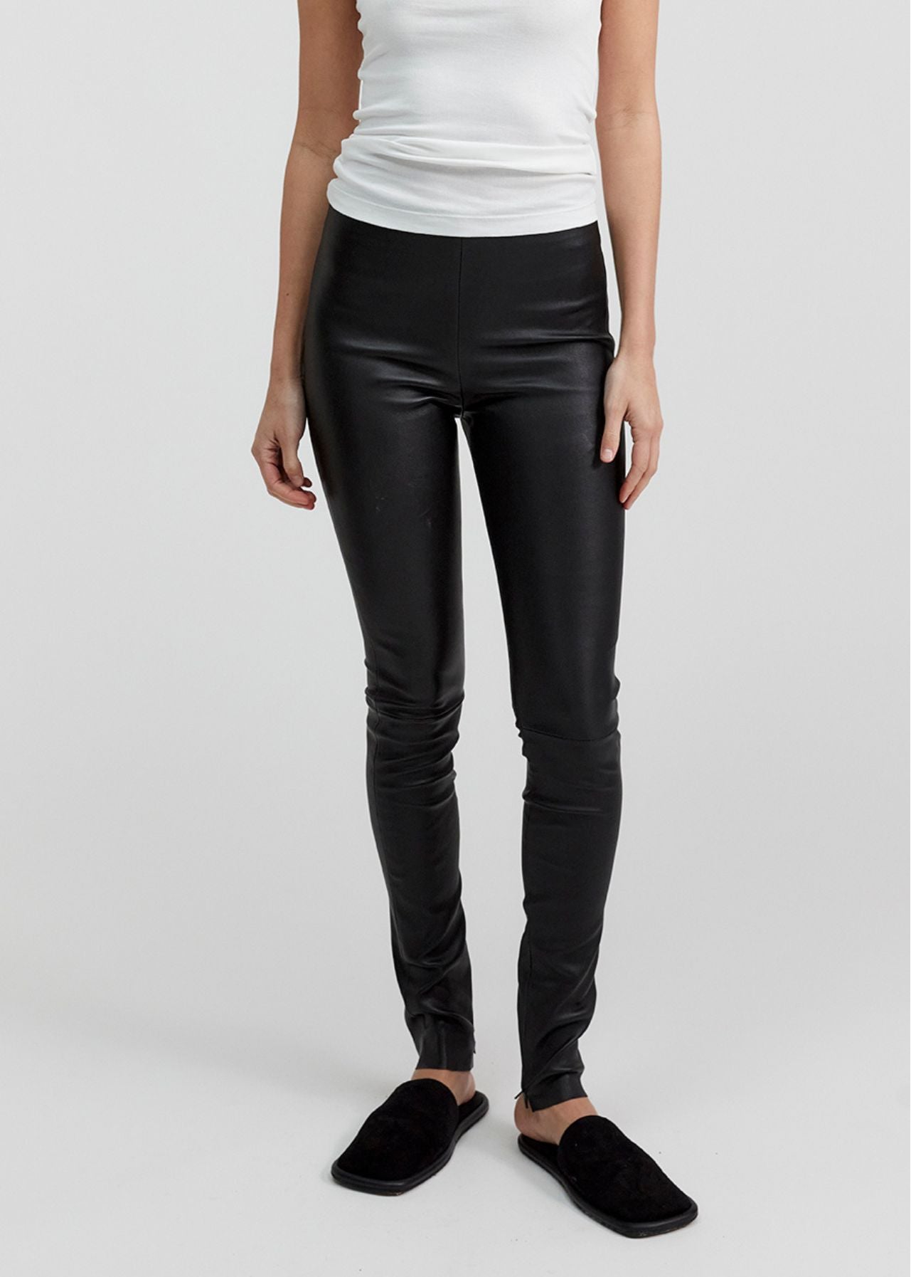 13541 LUKE UTZON aw24 black elastic lamb leather leggings styled with white tanktop and black slippers closeup of legs and tummy in stock