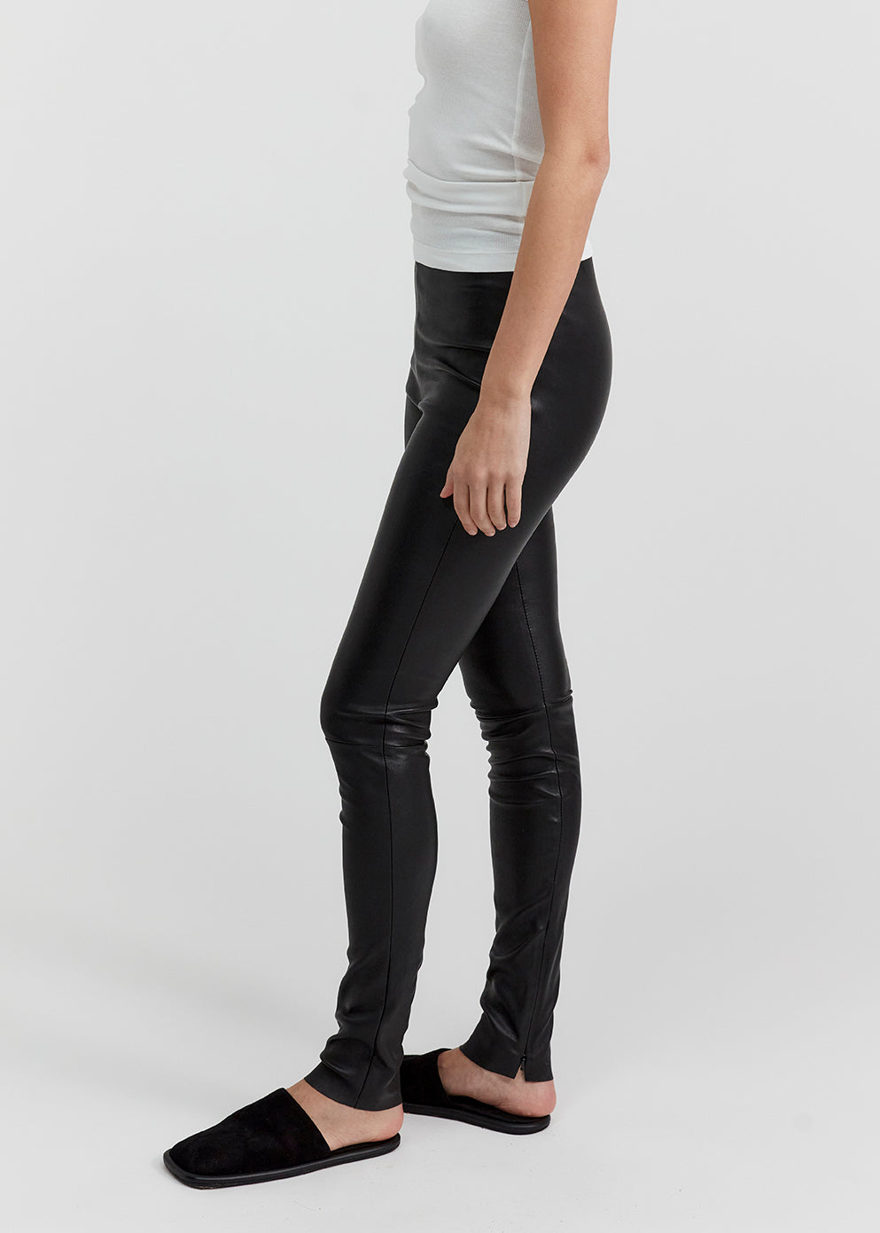 13541 LUKE UTZON aw24 black elastic lamb leather leggings styled with white tanktop and black slippers closeup of legs and tummy side