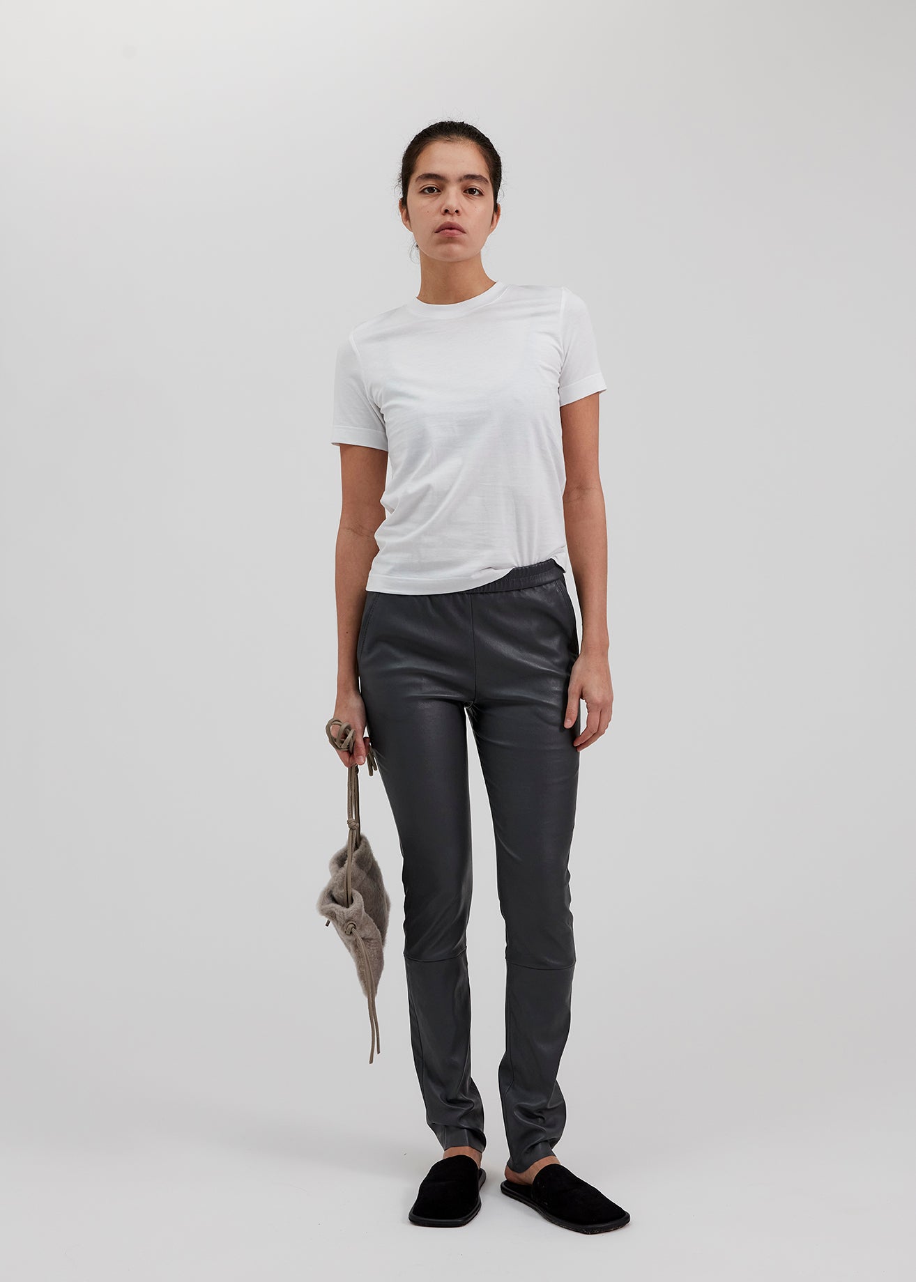 13546 PALMER UTZON aw24 elastic lamb leather pants styled with a white tshirt and black slippers model shown full body from the front