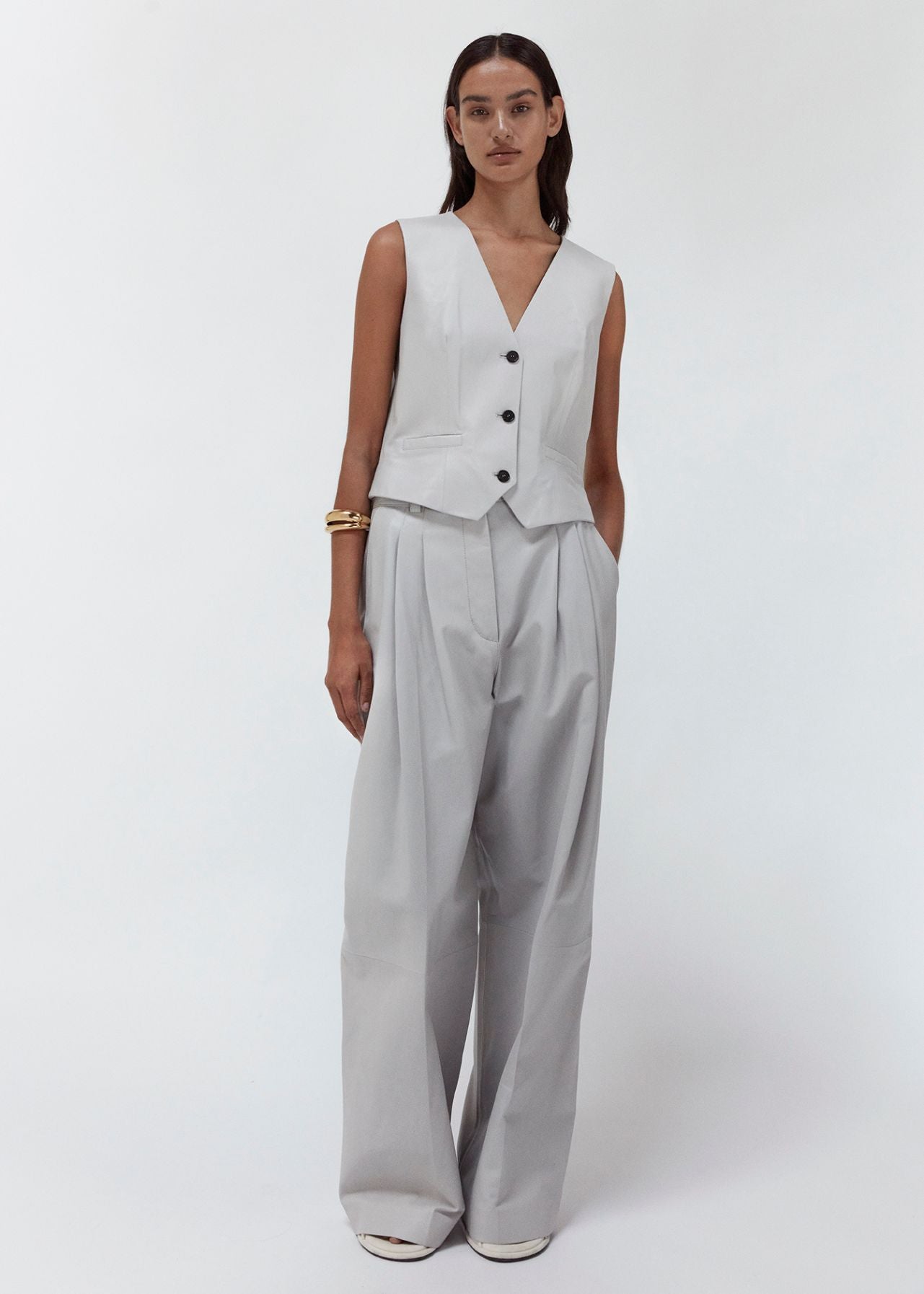 13547 PORTLYN UTZON aw 24 lamb leather pants with wide legs styled with a matching vest and a gold bracelet full body shot model shown from the front