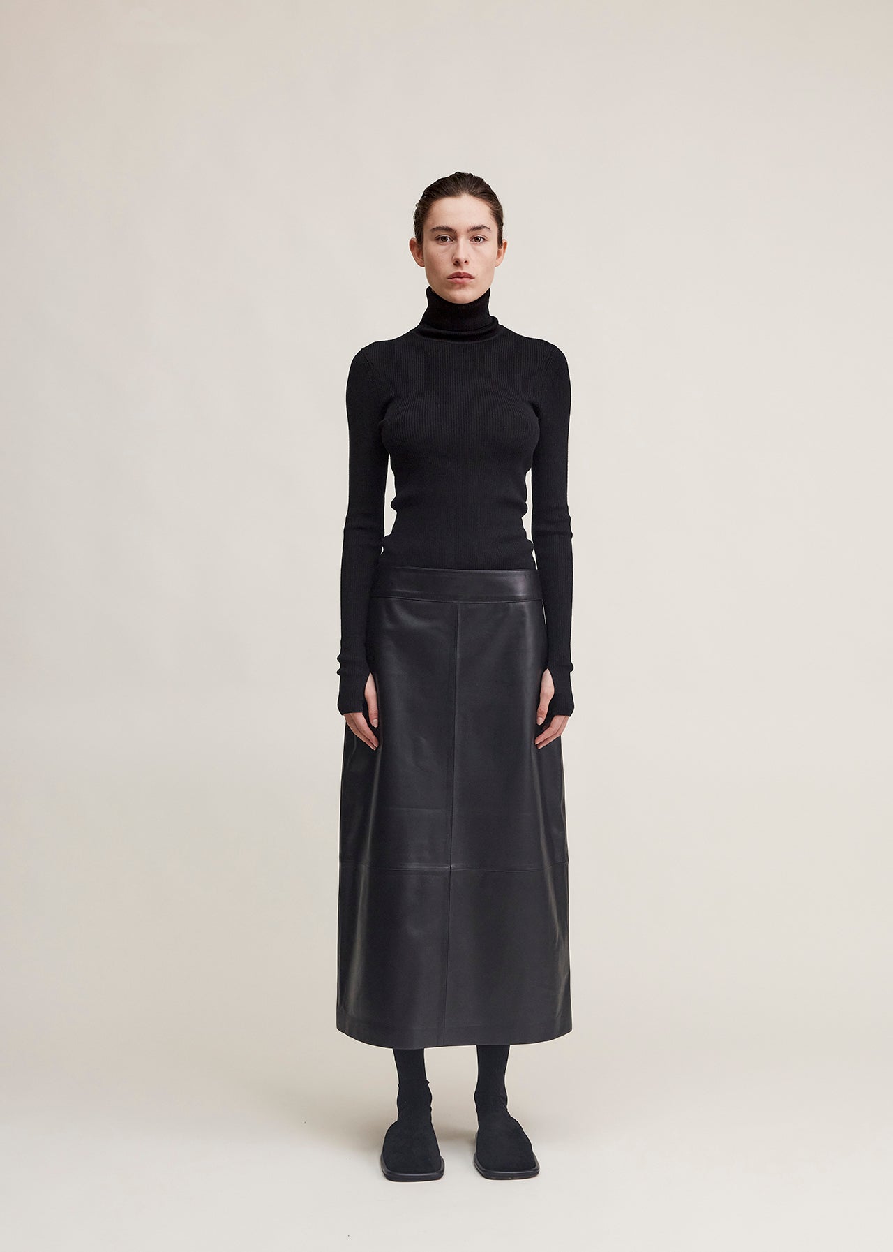 14424 NOAH UTZON aw24 black lamb leather nappa dragon skirt styled with a black top and black slippers model shown from the front full body