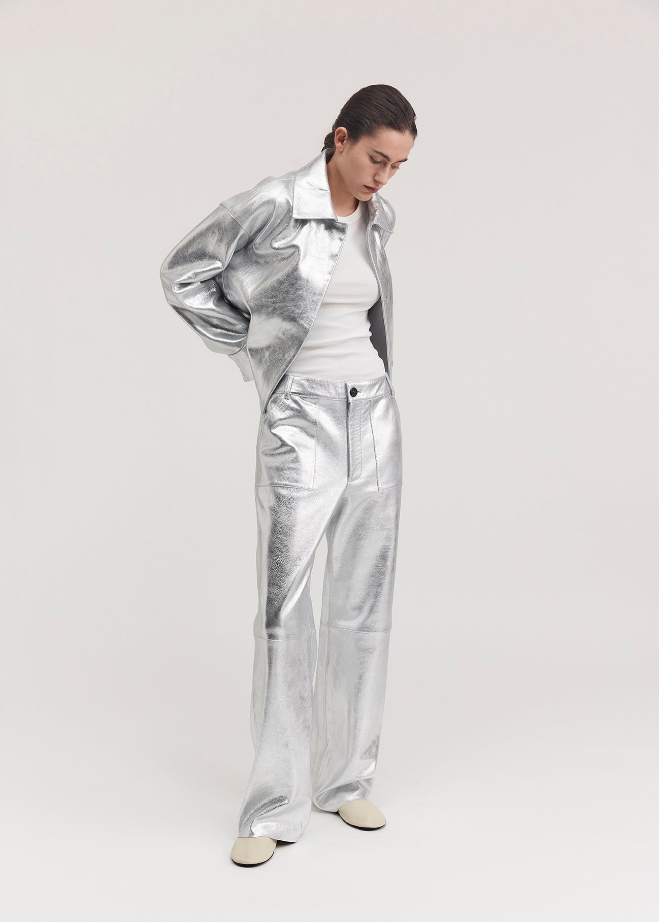 13528 BLANCE UTZON aw24 silver leather pants styled with a white tanktop and a matching jacket with hands behind back side front