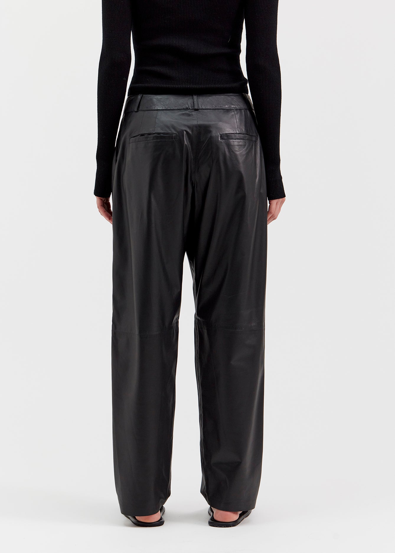 13542 PETER UTZON aw24 black lamb leather pants styled with a black top and black slippers close up of legs back