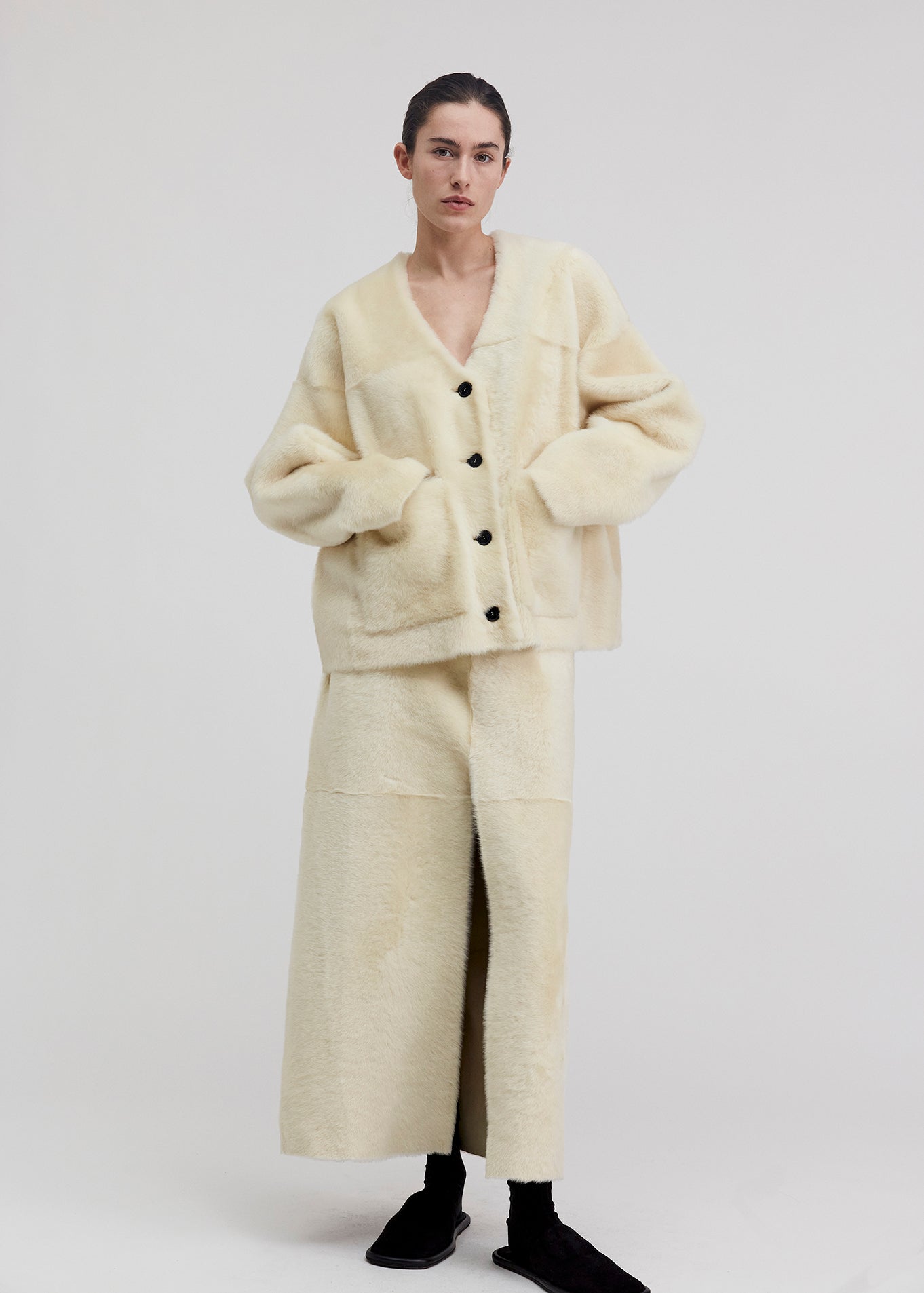 14422 NOEL UTZON aw24 lamb shearling baby lacon maxi skirt styled with black slippers and joseph jacket model shown from the front full body