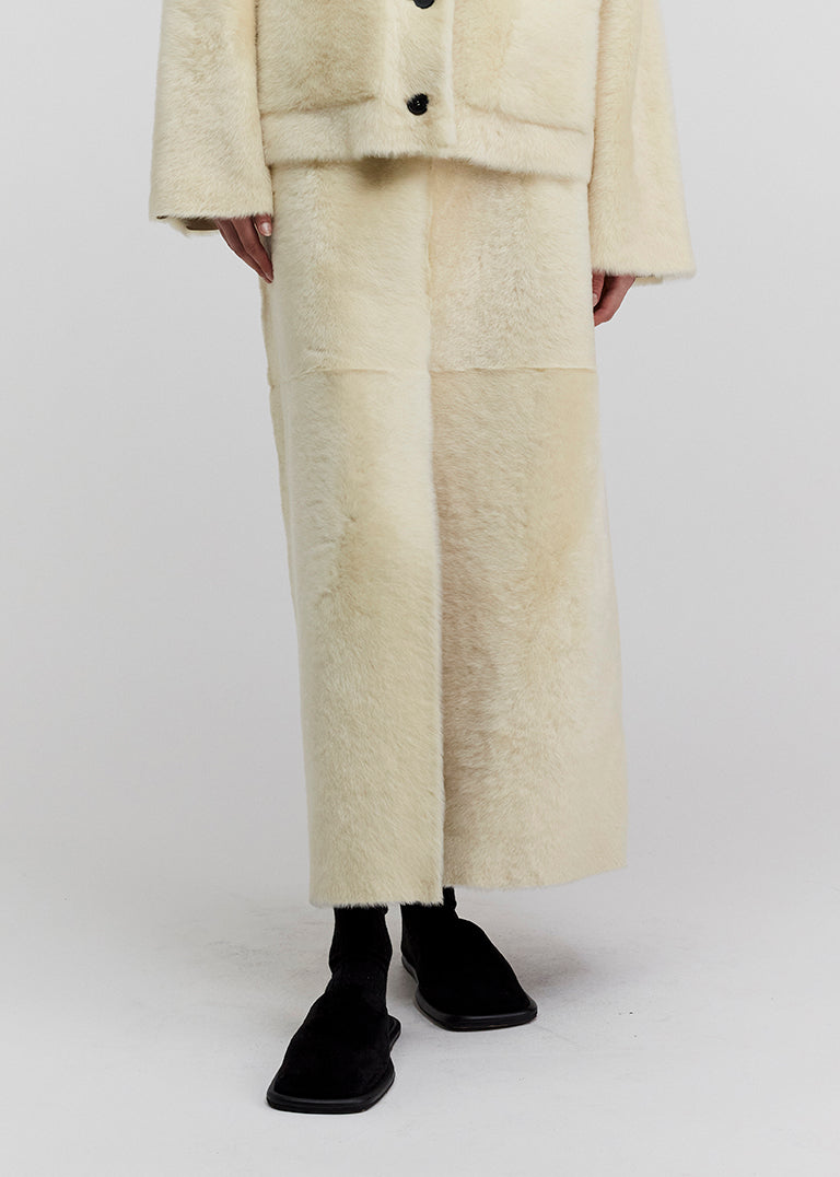 14422 NOEL UTZON aw24 lamb shearling baby lacon maxi skirt styled with black slippers and joseph jacket model shown from the front closeup of legs