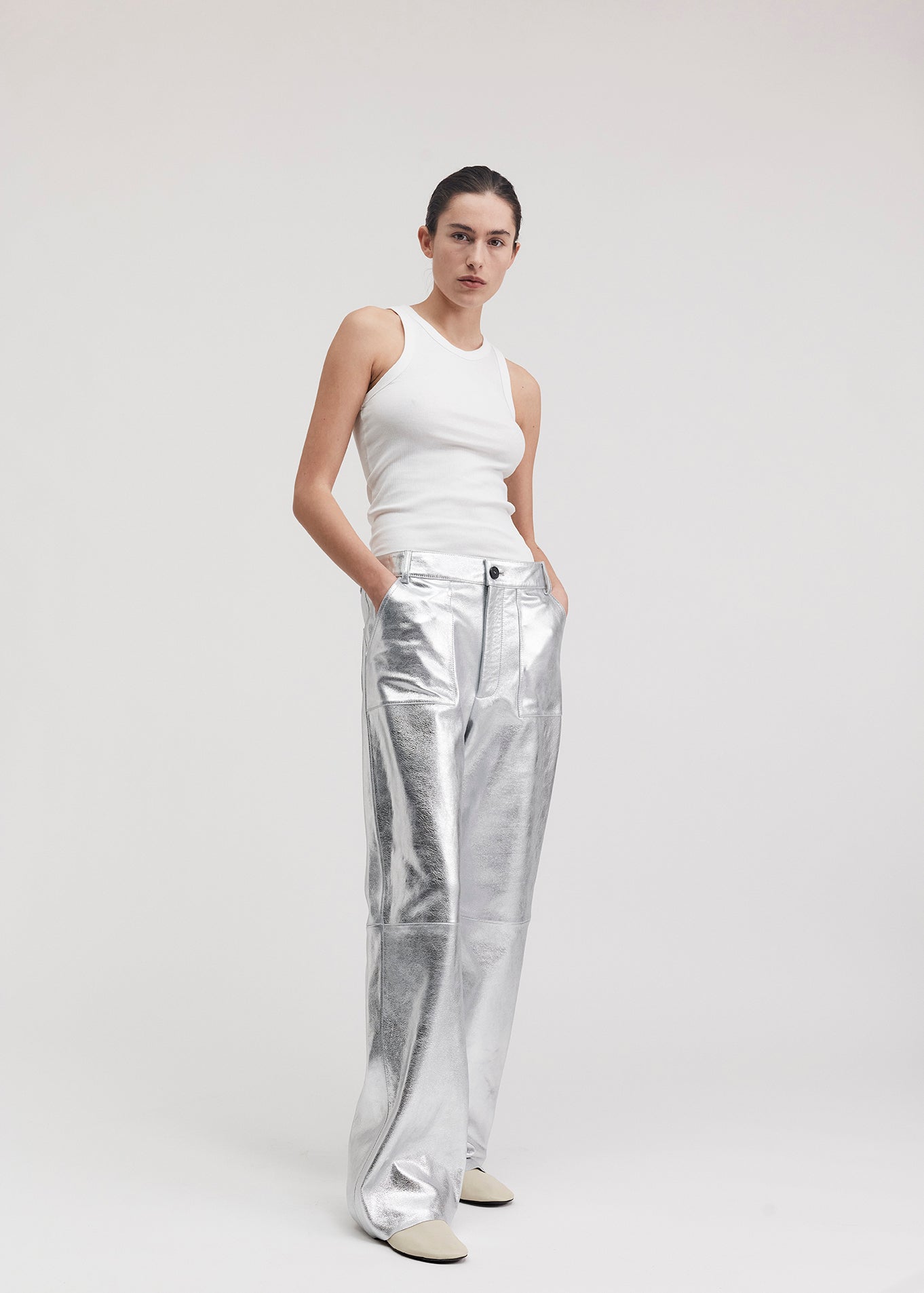 13528 BLANCE UTZON aw24 silver leather pants styled with a white tanktop model has hands in pocket side front
